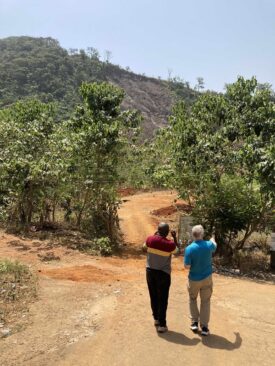 Elder Osse and Tom looking at the bare hill, where the landslide of 2017 took place.